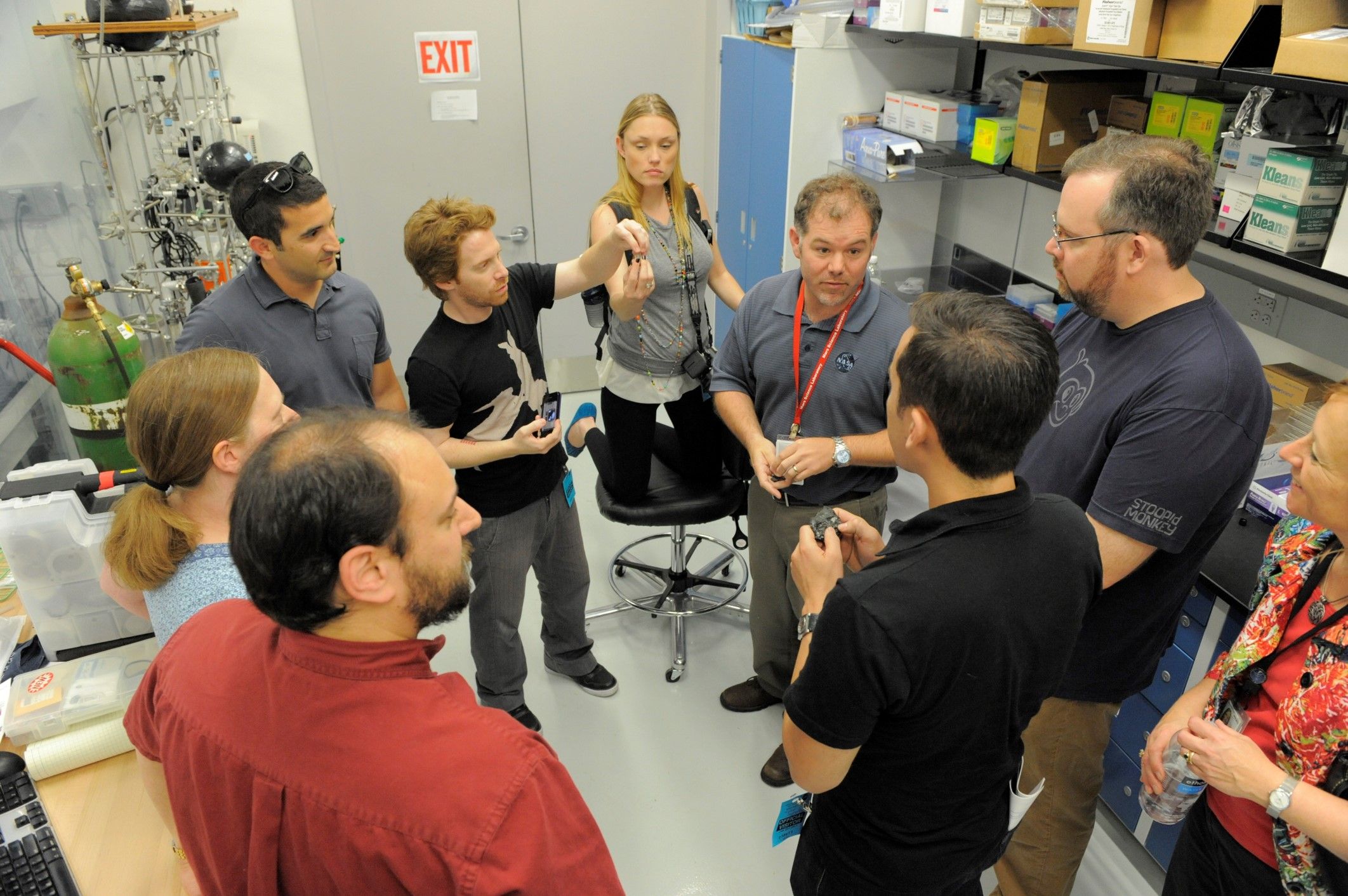 Eight people standing in a circle and having a discussion.