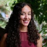 Woman with long curly dark hair smiling